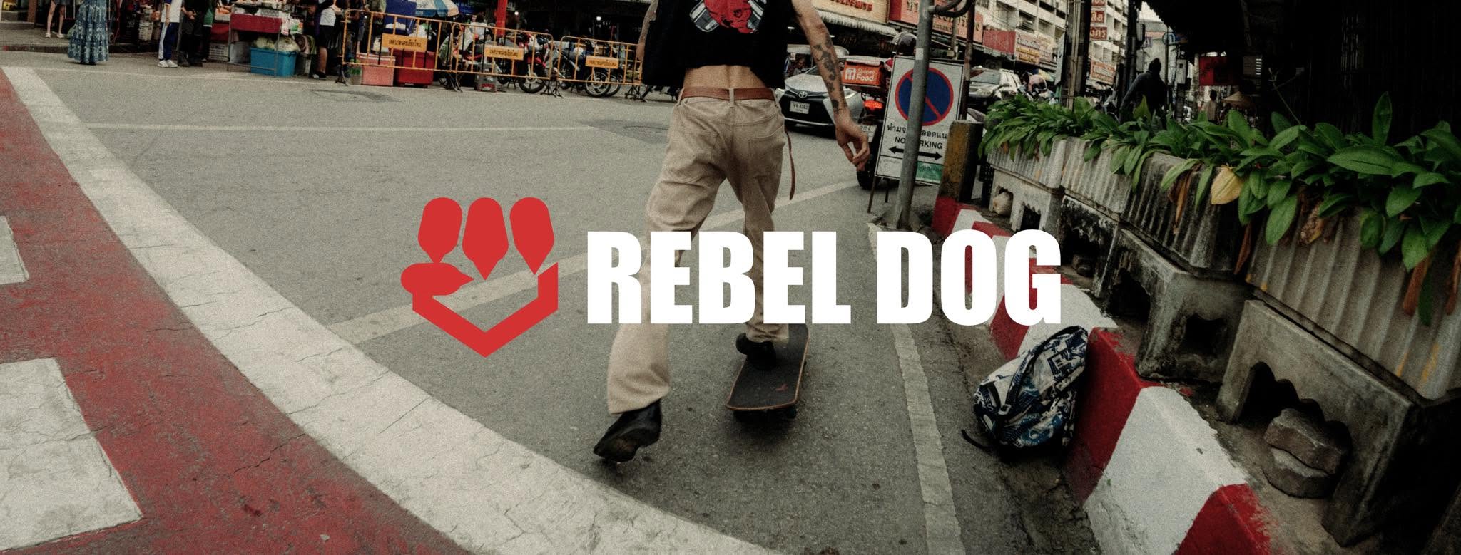 REBEL DOG banner — a skater crossing a street, red paw-fist logo overlaid